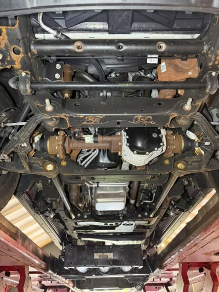 Untreated undercarriage showing surface rust on frame and suspension components